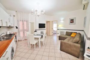 a kitchen and a living room with a couch and a table at Casa BuIIo in Chioggia