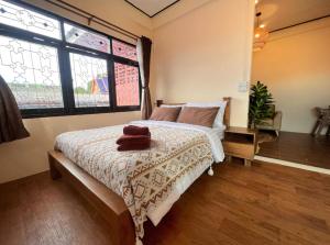 a bedroom with a bed and a large window at Papaya House Bangkok - Wat Arun in Bangkok Noi
