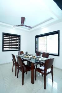une salle à manger avec une table et des chaises en bois dans l'établissement Malama Stay The Cloud Villa 4BHK Panchgani, à Mahabaleshwar