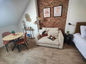 a living room with a chair and a table at Les Briques Rouges, Appartement Béthune in Béthune