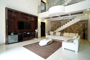 - un salon avec un canapé blanc et un escalier dans l'établissement Malama Stay The Cloud Villa 4BHK Panchgani, à Mahabaleshwar