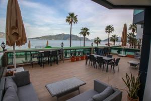 マルマリスにあるYuvam Prime Beach Hotelのテーブルと椅子があり、海の景色が見えるパティオ