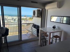 a room with a balcony with a table and chairs at NATURA LOFT in Cap d'Agde