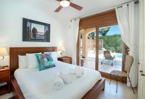 ein Schlafzimmer mit einem Bett und einer Glasschiebetür in der Unterkunft Villa Ceylon by Vintage Travel in Tamariu + 23 Fotos