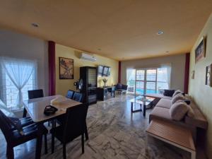 a living room with a couch and a table at Superb 3 Bed Pool Villa in Ban Saiyuan (1)