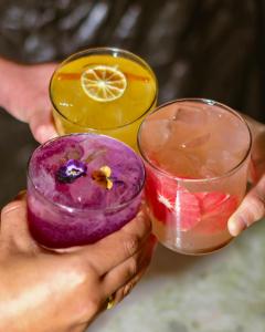 a person holding two cocktails in their hands at Beach Walk Boutique Jumeirah in Dubai