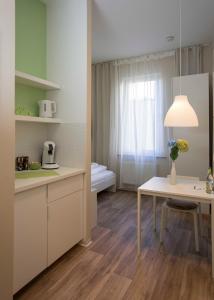 a kitchen with a table and a room with a bed at GuestHouse Köhn51, zentral gelegene, stilvoll eingerichtete Zimmer mit eigener Teeküche in Nürnberg