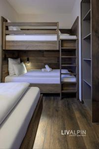 2 stapelbedden in een kamer met houten vloeren bij LIVALPIN Balance in Garmisch-Partenkirchen