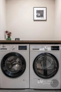 twee wasmachines in een kamer met een foto aan de muur bij LIVALPIN Balance in Garmisch-Partenkirchen