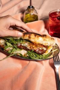 a person holding a plate of food with a sandwich at Beach Walk Boutique Jumeirah in Dubai