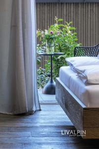 een slaapkamer met een tafel met een bed en bloemen bij LIVALPIN Balance in Garmisch-Partenkirchen +29 foto's