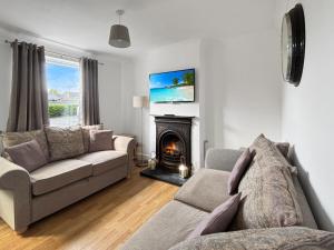 a living room with a couch and a fireplace at 3 Bed House Sleeps 8 Garden & Driveway - Central Location - Amaya 10 - Free Gym Access in Lincolnshire