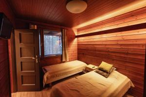 una piccola stanza con un letto e una finestra di Käenpesä a Kuusamo
