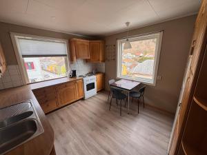 a small kitchen with a table and two windows at Apart, 4 pers, Central in Odda in Odda