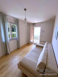 a living room with a bed and a large window at Rona Spacious apartment with a panoramic view in Ičići