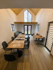 a dining room with tables and chairs and a window at EDANT HOUSE in Bumbesti Pitic