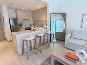 a kitchen and living room with a counter and a couch at 2 Bedroom In Waters Edge Voyage in Yas Island +12 photos