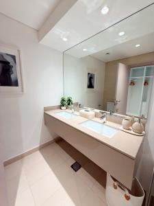 a bathroom with two sinks and a large mirror at 2 Bedroom In Waters Edge Voyage in Yas Island