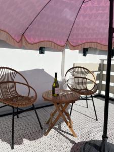 a table and chairs under a pink umbrella at Salty Breeze - Free Parking, quietly situated close to centre and beach! in Noordwijk