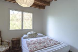 a bedroom with a bed and a window at Chalet de Gretteguerre in Lanne en Barétous