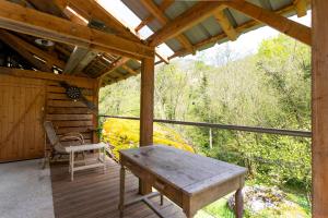 a porch of a cabin with a wooden table and chairs at Chalet de Gretteguerre in Lanne en Barétous +13 photos