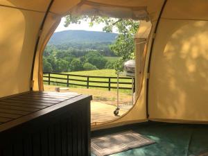 an inside view of a tent with a view of a field at Glamping Getaway on an Impressive Farm near Charlottesville, Virginia in Gordonsville