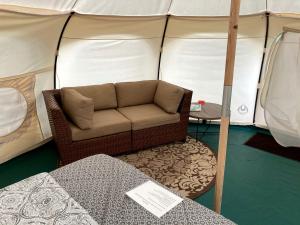 a couch in front of a tent with a table at Fantastic Virginia Glamping Retreat near Charlottesville in Gordonsville
