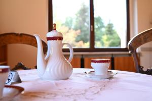 a white vase and a cup on a table at Pension Sonne Hartha in Hartha