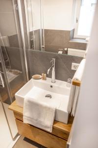 a bathroom with a white sink and a shower at Wanderers Neubau in Birkweiler