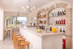 a bar with wooden stools and bottles on the wall at Alvia Suites in Corfu Town