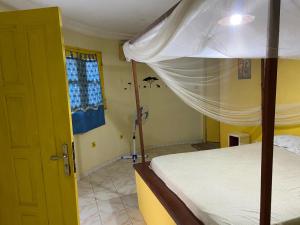 a bedroom with a bed and a open door at Kernico in Mbour