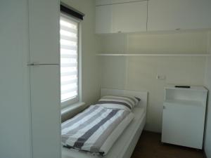 韦特林根Am See II - Lastering Ferienhäuser & Apartments的一间白色的小房间,配有床和窗户