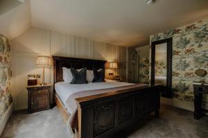 スタンフォードにあるThe Bull And Swanの大きなベッドと鏡のある寝室