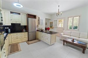 a kitchen with white cabinets and a couch in a room at Secret Valley - Chora's Hideaway in Andros +37 photos