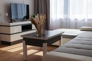 a living room with a table with a vase on it at Gero laiko oazė in Visaginas