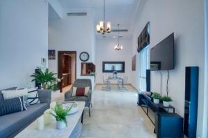 a living room with two couches and a tv at The Smart Concierge - Delphine in Dubai