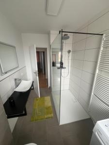 un bagno con doccia in vetro e lavandino di Geräumige Gästewohnung Andi im Herzen von Rastede - Küche - WLAN - Stellplatz a Rastede Altre 16 foto