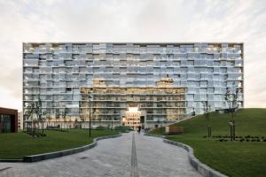 a large building with a lawn in front of it at Fredika, modern 1br,Tripla Pasila prime location, gym, parking, train station near in Helsinki