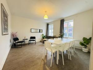 a living room with a white table and chairs at aday - 8 bedroom Apartment on the Pedestrian Street in Aalborg
