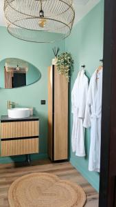 a bathroom with a rack of white towels and a mirror at Toi et moi Love room avec Hammam, Sauna, Balnéothérapie ensemble privatisés in Le Coudray