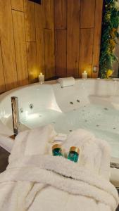 a bathroom with a bath tub with towels and candles at Toi et moi Love room avec Hammam, Sauna, Balnéothérapie ensemble privatisés in Le Coudray