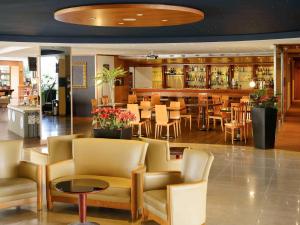 a restaurant with chairs and tables and a bar at Novotel Porto Gaia in Vila Nova de Gaia
