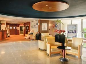 a lobby with a waiting room with yellow chairs at Novotel Porto Gaia in Vila Nova de Gaia
