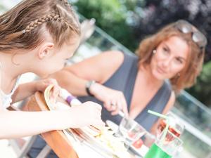 two women sitting at a table eating food at Novotel Porto Gaia in Vila Nova de Gaia