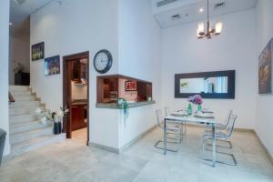a dining room with a table and a clock on a wall at The Smart Concierge - Delphine in Dubai
