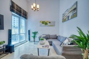 a living room with a couch and a table at The Smart Concierge - Delphine in Dubai
