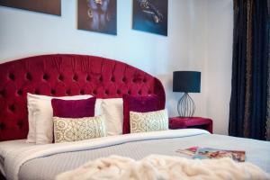a red bed with pillows and a red headboard at The Smart Concierge - Delphine in Dubai
