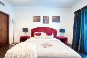 a bedroom with a large bed with a red headboard at The Smart Concierge - Delphine in Dubai