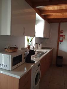 a kitchen with a microwave sitting on a counter at Casinha das Estrelas in Cerejeira
