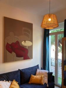 a living room with a blue couch and a painting at Evasion Marine 1 in Palavas-les-Flots